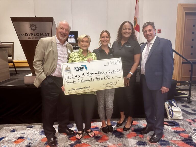 5 people holding a large check for the city of neptune beach for 2,500