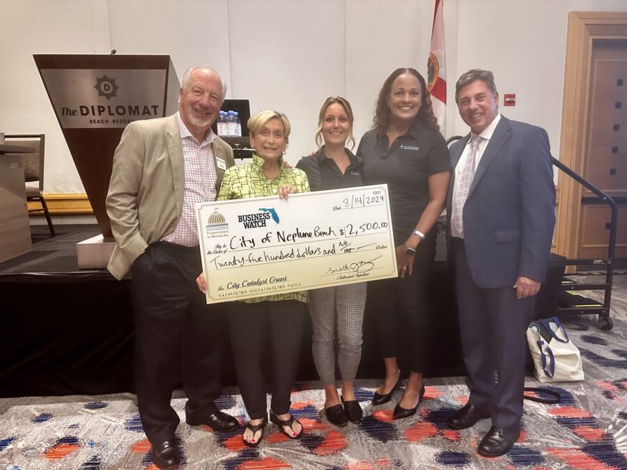 5 people holding a large check for the city of neptune beach for 2,500